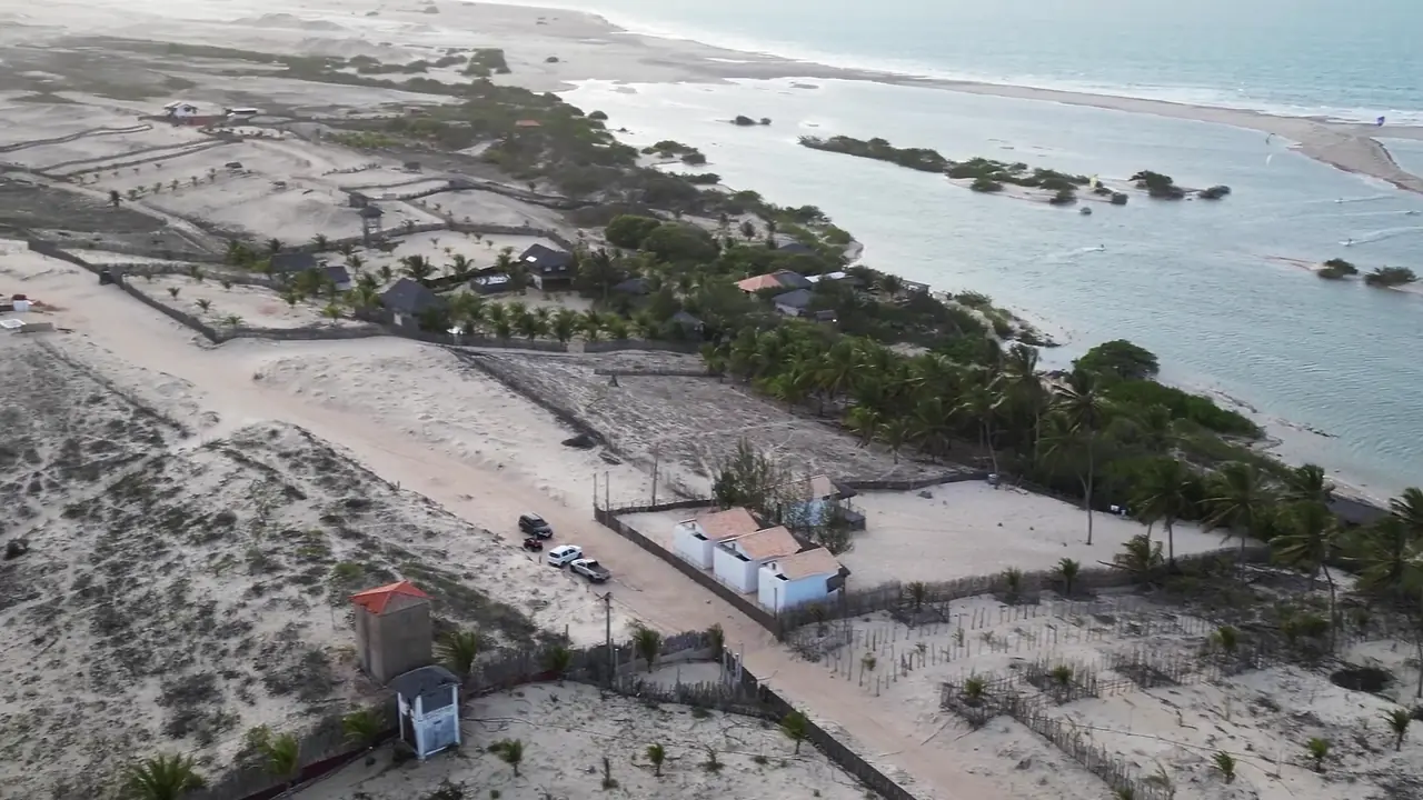 Vista aérea da vila de Tatajuba, no Ceará, com casas entre as dunas e a lagoa com bancos de areia ao fundo