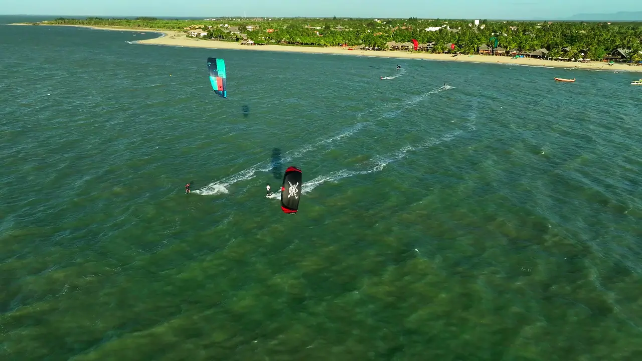 Kitesurf em Barra Grande, no Piauí, com água azul-turquesa e a vila ao fundo