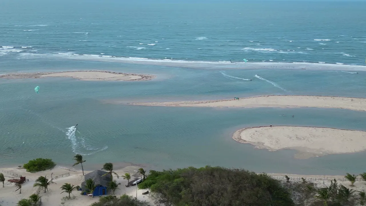 Vista aérea da lagoa de água plana e dos bancos de areia de Tatajuba, no Ceará, com o mar ao fundo